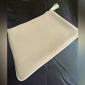 Beige leather Kate Spade clutch with tassel.